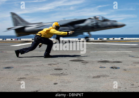 L'Aviation de l'US Navy un manoeuvrier Mate signale un Harrier AV-8B II fighter jet pour lancer sur le poste de pilotage de l'assaut amphibie USS Wasp 27 juillet 2013 opérant dans l'océan Atlantique. Banque D'Images