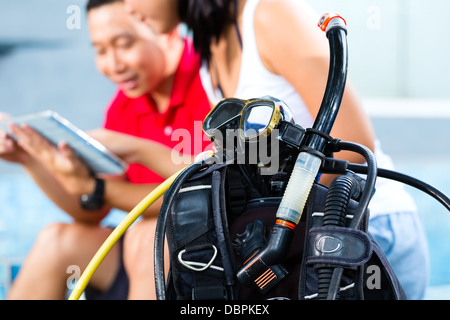 Asiatiques, divingmaster et étudiant à l'diver en vacances avec wetsuit et tablet computer Banque D'Images
