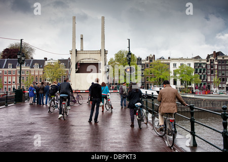 Les gens qui attendent sur le pont Maigre levée (néerlandais : Magere Brug) sur la rivière Amstel à Amsterdam, Hollande, Pays-Bas. Banque D'Images