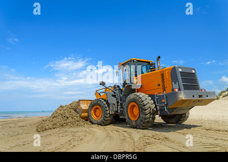 Le bulldozer Nettoie la saleté sur une plage après une tempête Banque D'Images