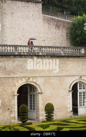 Un couple à l'abri sous un parapluie lors d'une douche lourde. Banque D'Images