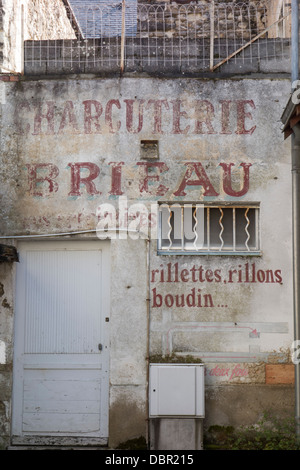 Vieux et a disparu à la publicité écrite sur le dos d'une boutique de bouchers en France Banque D'Images