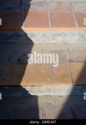 Libre d'un escalier en terre cuite carreaux en céramique casting shadows dans un motif en zigzag. Banque D'Images