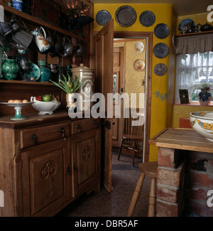 Collection de cruches en étain sur la vieille commode en pin cuisine rétro avec groupe de plaques en étain au-dessus de la porte Banque D'Images