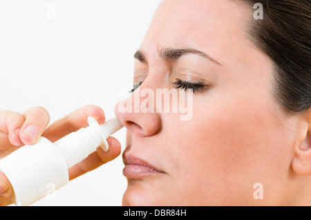 Une jeune femme à l'aide de spray nasal Banque D'Images