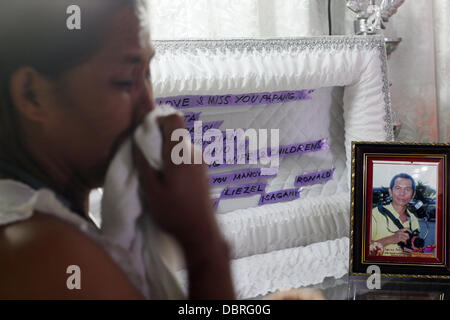 La ville de General Santos, Philippines du Sud. 3 Août, 2013. L'épouse de Mario Sy Violeta Sy le deuil à l'intérieur de trèves chambre après le corps de Mario Sy seulement arrivent dans leur chambre à midi à Santa Cruz Silway, General Santos City, Philippines du Sud, 03 août 2013. Offres news photographe Mario Sy a été tourné à l'intérieur de son domicile Vendredi, 01 août 2013. Sy a contribué à "photos de presse à l'APOL News Bulletin(Sur cible News Bulletin). Jubelag Sapol Editeur Jonh Paul a déclaré que la question des drogues illégales dans la zone Sy pourrait être le motif. Banque D'Images