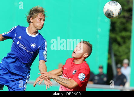 Londres, Royaume-Uni. 06Th Aug 2013. Neustrelitz's Thomas Franke (L) rivalise pour le bal avec Fribourg Jonathan Schmid lors du premier tour de la coupe DFB entre TSG Neustrelitz et SC Freiburg au Parkstadion à Neustrelitz, Allemagne, 03 août 2013. Photo : JENS BUETTNER (VEUILLEZ NOTER : La DFB interdit l'utilisation et la publication d'images séquentielles sur l'internet et autres médias en ligne pendant le match (y compris la mi-temps). Période de blocage ! La DFB permet l'utilisation et la publication des photos pour les services mobiles (MMS) et en particulier pour le DVB-H et DMB qu'après la fin de Banque D'Images