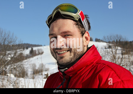 Portrait de jeune homme sourit en hiver les montagnes avec snowboard Banque D'Images