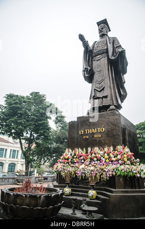 Empereur Ly Thai à la statue de bronze Vieux quartier Hanoi Vietnam / HANOI, Vietnam — Une statue en bronze du fondateur de la dynastie Lý, l'empereur Lý Thái Tổ, se tient derrière un brûleur d'encens en forme de lotus près du Vieux quartier. Le rouleau dans sa main droite représente l'édit de 1010 sur le transfert de la capitale, qui a déplacé la cour royale à Thăng long - aujourd'hui Hanoi - établissant la ville comme centre politique du Vietnam pour le prochain millénaire. Banque D'Images
