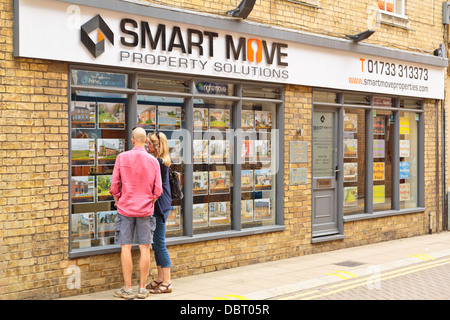 Couple vente maison à un agent immobilier vitrine, Peterborough, England Banque D'Images