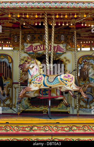 Cheval au galop à vapeur carrousel, fairground ride à un bain à vapeur juste. L'Angleterre Banque D'Images