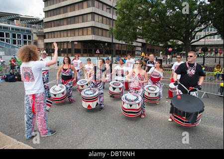 Londres, Royaume-Uni. 3e août 2013. Batala samba carnaval de tambours à Victoria Embankment cyclistes passant donner crédit de divertissement : Malcolm Park/Alamy Live News Banque D'Images