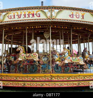 Cheval au galop à vapeur carrousel, fairground ride à un bain à vapeur juste. L'Angleterre Banque D'Images