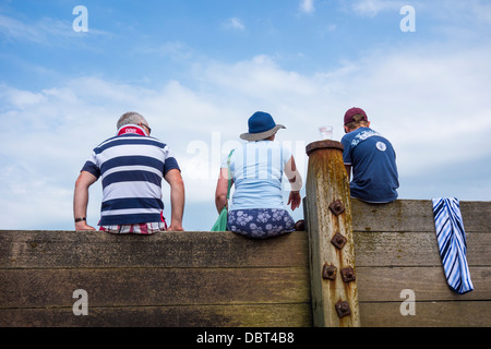 Maison de vacances en bord de grands-parents et petit-fils assis sur un épi Whitstable Banque D'Images