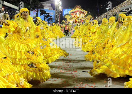 Une troupe de danseurs en robes jaune dans le Sambadrome de carnaval de Rio de Janeiro, Brésil, le lundi 11 février 2013. Banque D'Images