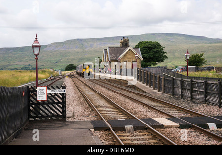 Passenger train arrivant en gare Ribblehead sur l'installer - ligne de Carlisle. Banque D'Images