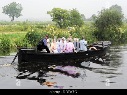 Les touristes s'asseoir dans un récipient sur le gazon Hamme rivière à travers le Teufelsmoor moorland de Osterholz-Scharmbeck à Neu Helgoland près de Worpswede, Allemagne, 25 juillet 2013. À partir de la tourbe le Teufelsmoor moorland utilisé pour être transportés par ces bateaux black oak à l'orifice de la tourbe à Brême. Photo : Ingo Wagner Banque D'Images