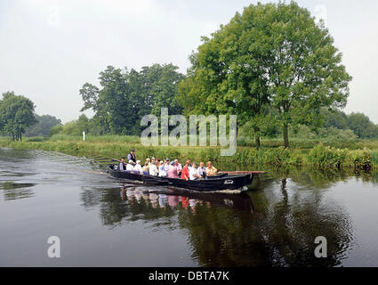 Les touristes s'asseoir dans un récipient sur le gazon Hamme rivière à travers le Teufelsmoor moorland de Osterholz-Scharmbeck à Neu Helgoland près de Worpswede, Allemagne, 25 juillet 2013. À partir de la tourbe le Teufelsmoor moorland utilisé pour être transportés par ces bateaux black oak à l'orifice de la tourbe à Brême. Photo : Ingo Wagner Banque D'Images