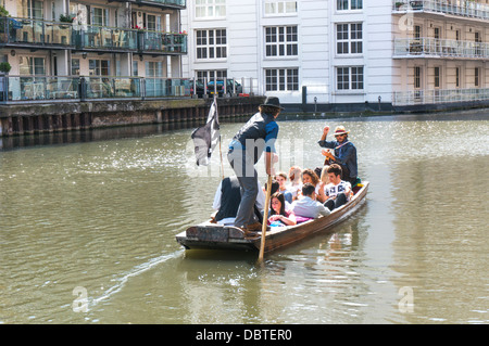 Un punt bateau avec les touristes à bord et un guitariste, à Camden Lock, près de Camden Market, Londres, Angleterre, Royaume-Uni. Banque D'Images