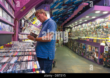 Un homme parcourt dans un magasin de disques, avec un plafond de guitare, à Camden Market, Londres, Angleterre, Royaume-Uni. Banque D'Images