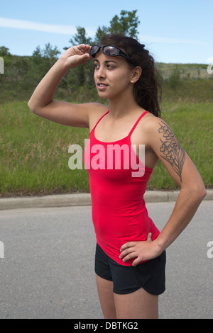 FIT femme avec un tatouage floral prêt à aller pour une course à la recherche d'une rue de ville Banque D'Images