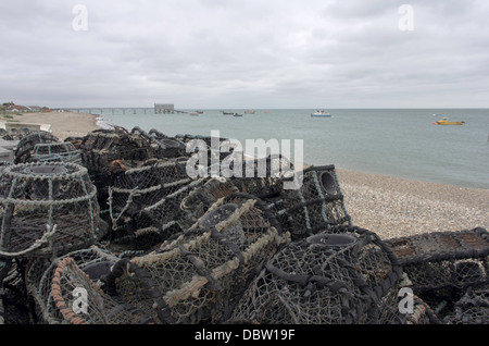 Des casiers à homard sur Selsey plage avec le poste de recherche et sauvetage clairement visible à l'arrière-plan. Banque D'Images