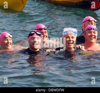 Singer Ronan Keating, les présentateurs de télévision Jenny Frost et Jason Bradbury, et strictement star Pamela Stephenson ont terminé un marathon de natation de collecte de fonds à travers la mer d'Irlande. La nageuse médaillée olympique dirigée par Steve Parry, ils ont tous touché terre sur une plage à ni Banque D'Images