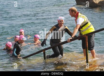 Singer Ronan Keating, les présentateurs de télévision Jenny Frost et Jason Bradbury, et strictement star Pamela Stephenson ont terminé un marathon de natation de collecte de fonds à travers la mer d'Irlande. La nageuse médaillée olympique dirigée par Steve Parry, ils ont tous touché terre sur une plage à ni Banque D'Images