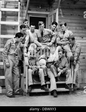 1940 GROUPE DE SOLDAT SITTING ON STEPS de casernes à l'écoute de l'homme jouant du banjo Banque D'Images