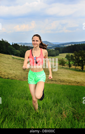 Jeune femme jogging en face de cross country Banque D'Images