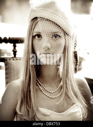 Un millésime 1920 inspiré photographie d'une femme blonde en perles élégant et un chapeau voilée Banque D'Images