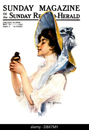 Années 1900 Années 1910 SMILING WOMAN WEARING HAT ATTACHÉ AVEC GRAND BLUE BOW HOLDING BIRD 15 MAI 1910 SUNDAY MAGAZINE COVER Banque D'Images