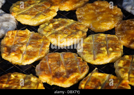 Gâteaux de riz frits sur charbons. Marché libre en Thaïlande Banque D'Images