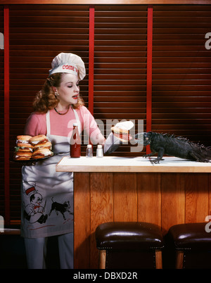1950 FEMME PORTANT CHAPEAU DE CHEF DE L'aire d'alimentation des hamburgers à hamburger sur les comptoirs de l'iguane Banque D'Images
