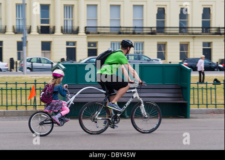 L'homme et de la jeune fille équitation tandem le long front de mer de Brighton East Sussex England UK Banque D'Images