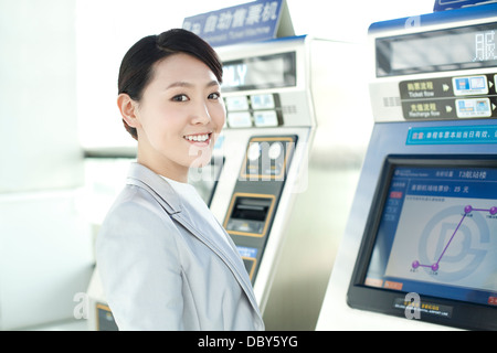 Young businesswoman at metro ticket machine Banque D'Images