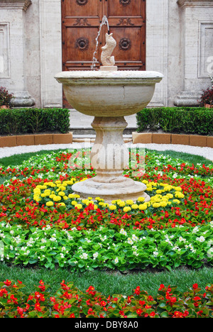 Jardin avec fleurs de couleur en face de la cathédrale de Pienza dans les collines de Toscane de l'Italie. Banque D'Images
