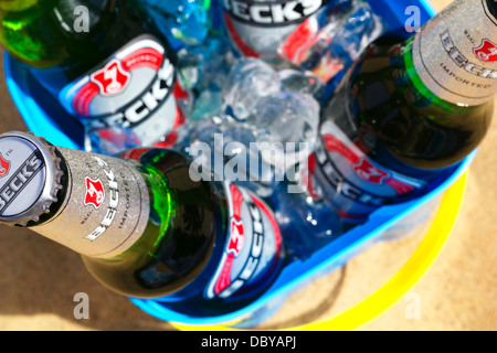 Les bouteilles de bière Becks avec de la glace dans le château de sable sur la plage de godet. Banque D'Images