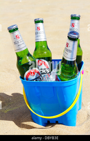 Les bouteilles de bière Becks avec de la glace dans le château de sable sur la plage de godet. Banque D'Images