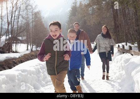 Happy Family running in snowy lane Banque D'Images