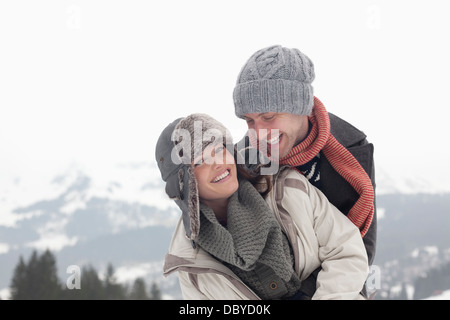 Portrait of enthusiastic couple hugging avec montagnes en arrière-plan Banque D'Images