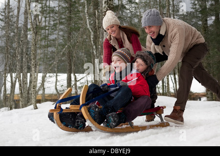 Happy Family Sledding in Snowy Woods Banque D'Images