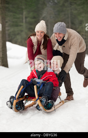 Happy Family Sledding in Snowy Woods Banque D'Images