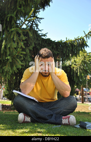 College student couché dans l'herbe au soleil Banque D'Images