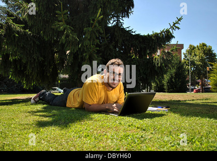 College student couché dans l'herbe au soleil Banque D'Images