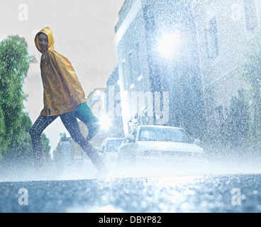 Femme marchant pieds nus sur rainy street Banque D'Images