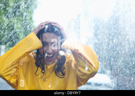 Happy woman with hands on head dans la pluie Banque D'Images