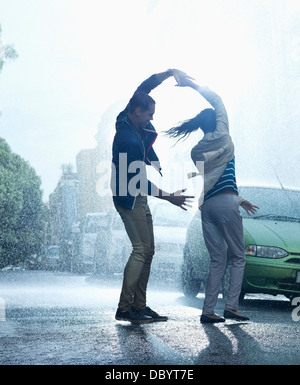 Heureux couple dancing in rain Banque D'Images