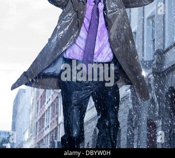 Businessman running in rain Banque D'Images