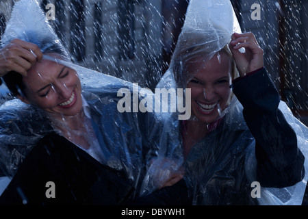 Rire dans la pluie ponchos femmes portant Banque D'Images